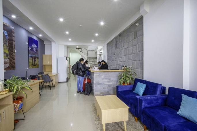 Reception, a welcoming and modern lobby with cozy blue sofas and Andean-inspired decor, featuring an elevator at the back for access to all five floors.