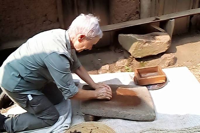 Hands-on traditions! 🌾✨ A guest experiencing authentic, traditional stone grinding during our Bigodi village walk. Real cultural immersion with Oasis Safaris.