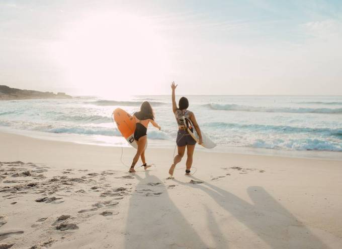 Zwei Menschen, die an einem sonnigen Tag surfen gehen wollen