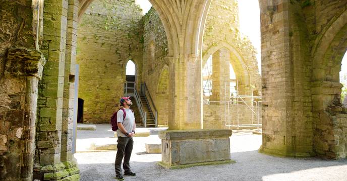 Un homme se promène dans les ruines de l'abbaye de Jerpoint à Kilkenny en Irlande