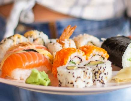 Gros plan d'une femme servant un plateau de sushis à Tokyo lors d'un circuit culinaire au Japon