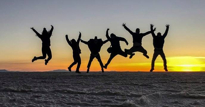 A group of friends jumping with excitement at the Uyuni Salt Flats