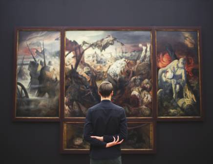 Un homme regarde des œuvres d'art dans une galerie en Pologne pendant un voyage culturel