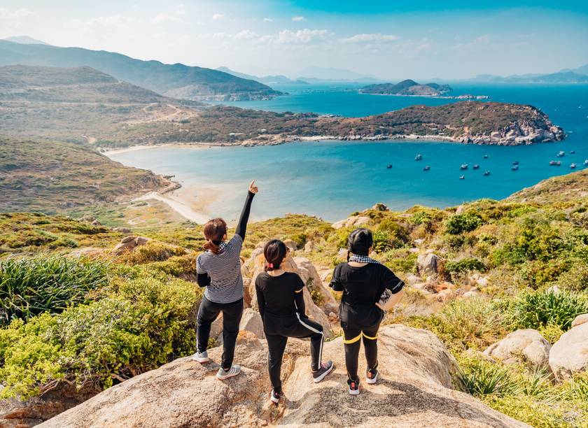 Een groep vrienden viert feest bij het bereiken van hun panoramische top tijdens een trektocht door Vietnam