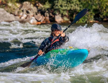 Eine Person fährt Kajak auf einem malerischen Fluss in den USA