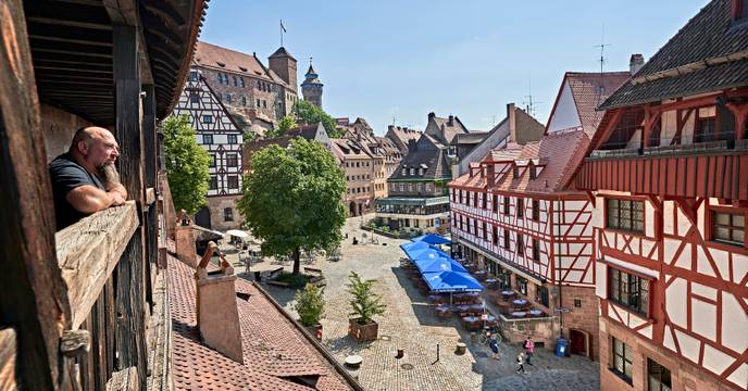 Wide view of people walking through the architecturally-beautiful streets of Nuremberg, Bavaria