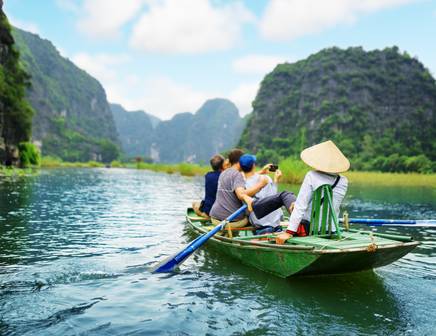 people in a traditional boat exploring halong bay
