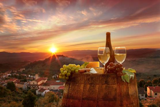 Sunset view of rolling hills with a bottle of wine and grapes