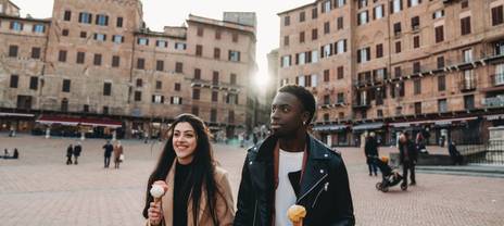 Couple se promenant dans une ville italienne et dégustant une glace