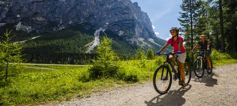 Couple cycling with a view of meadows and mountains