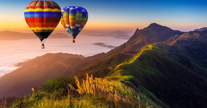 Balloons flying over lush landscapes in India