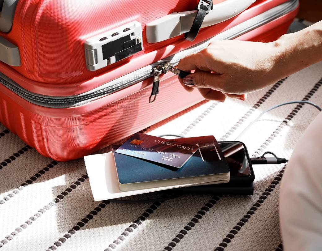 Ein roter Koffer, vollgepackt mit Pässen und Flugtickets, daneben