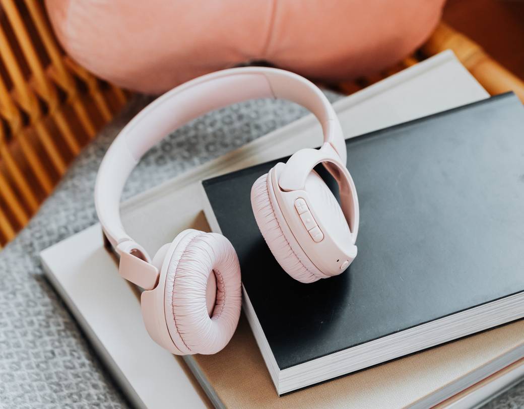 Nahaufnahme eines Stapels von elektronischen Geräten, darunter ein Tablet und voll aufgeladene Kopfhörer