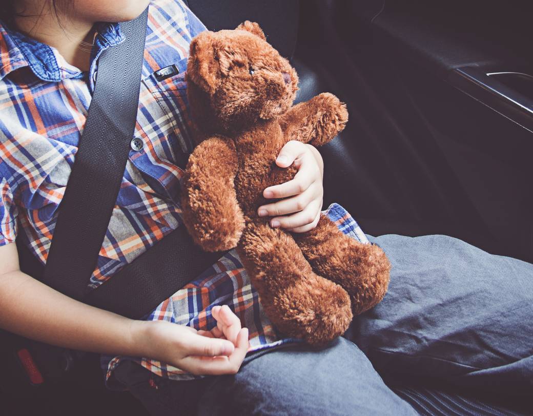 Nahaufnahme eines Kleinkindes, das im Familienurlaub einen Teddybären hält