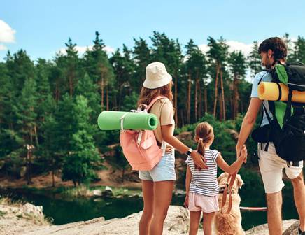 Eine Mutter, ein Vater, eine Tochter und ihr Hund auf einer Wandertour durch die Nationalparks
