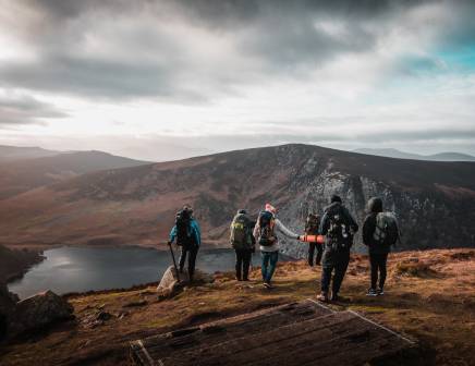 Group of hikers standing and admiring Irish highlands.