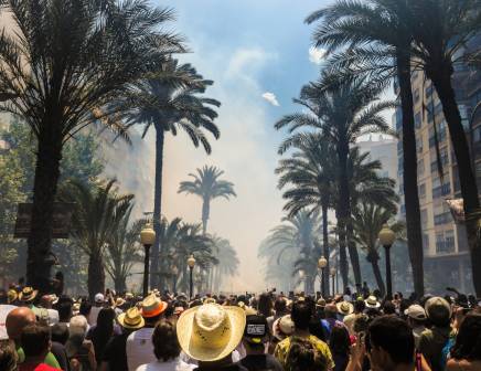 Busy street with palm trees on both sides.