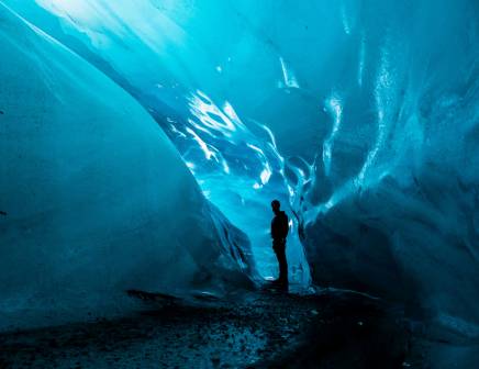 Silhouette of a man standing in an ice cave.