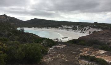 Secluded beach with white sand and surrounding cliffs.