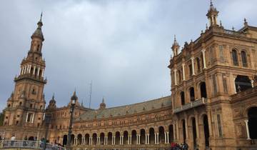 Wide view of Plaza de España with towers and arches.