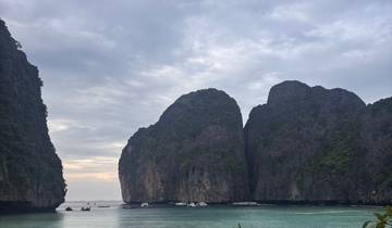 A scenic beach with rocky cliffs and clear water.