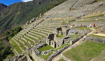 Terrace ruins with green grass and the Andes in the background.