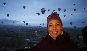 Person with background of hot air balloons over a scenic valley.