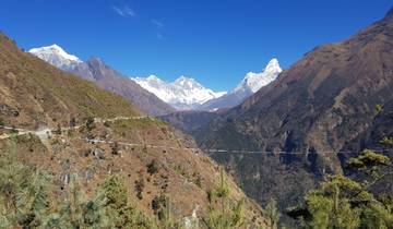 A scenic view of the valley with snow-capped mountains in the background.