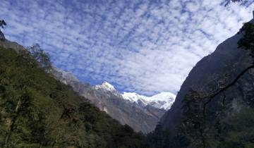 Majestic mountainous landscape with snow peaks under a stratified sky.