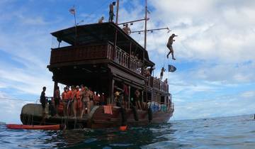 Several people jumping from a boat into the water.