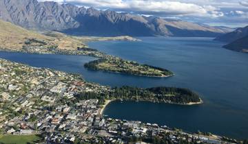 Aerial view of a city, lake, and surrounding mountains.
