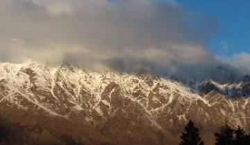 Snow-covered mountains under a cloudy sky.