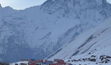 Snowy mountain landscape with small roofs visible.