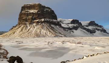 Snowy mountain and frozen landscape under a blue sky.