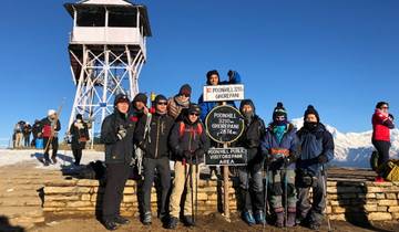 Group of hikers with signpost at Poon Hill in the snow.