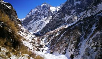 Snow-covered mountain range under a bright blue sky.
