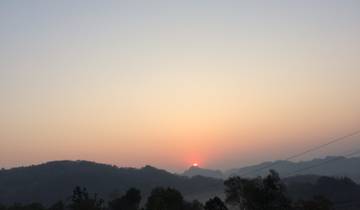 Sunset view over hills with a clear sky.