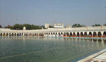 A large pool area surrounded by a grand building with domes.