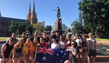 Group of people posing in front of a fountain with a flag.