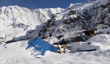Snow-covered mountain landscape with blue corrugated metal structures.