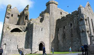 Ancient stone castle with people walking around.