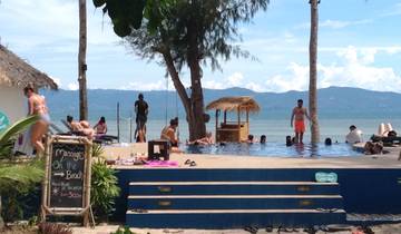 People enjoying time at an infinity pool situated near a beach.