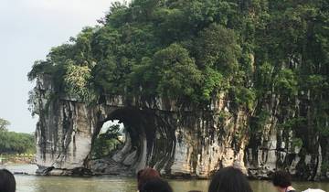 Karst mountain with an arch formation above a river.