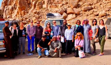 A group of people posing in front of rugged rocky scenery.