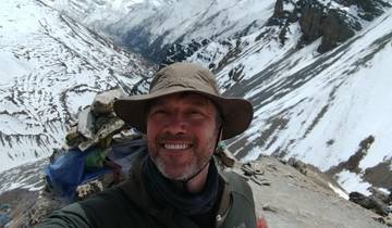 Person on a snowy mountain trail wearing a hat.