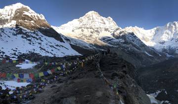 Majestic mountain peaks with prayer flags in the foreground.