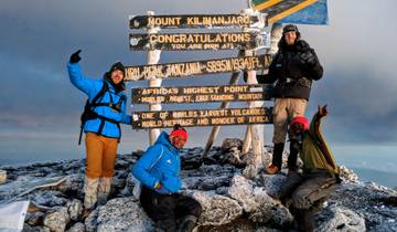 Climbers celebrating at the summit of Mount Kilimanjaro.