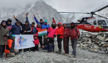 Group of trekkers with a helicopter and snowy mountains.