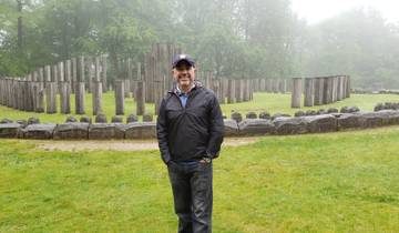 Man standing in front of ancient stone structures.