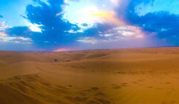Vast desert landscape under a colorful sky.